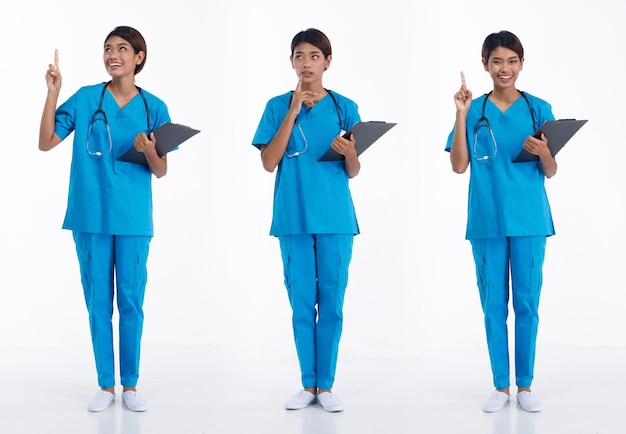Volledige lengte 20s jonge aziatische verpleegster vrouw draagt stethoscoop blauw uniform wijzende vinger hand in de lucht
