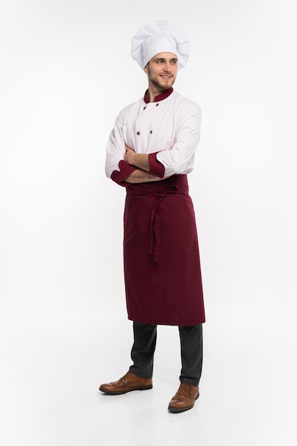 Volledige lengte portret van positieve knappe chef-kok in baret en witte outfit geïsoleerd op een witte achtergrond