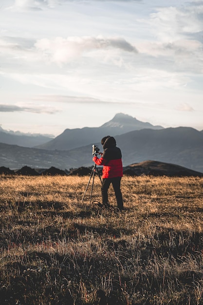 Volledige lengte van de man die op het veld tegen de lucht fotografeert