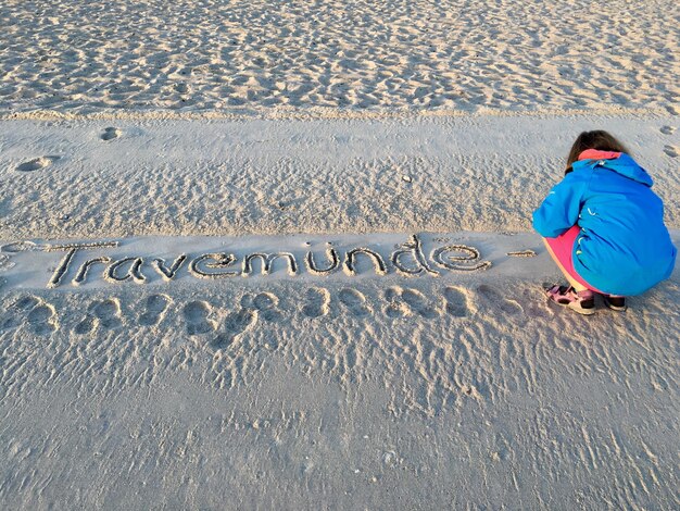 Foto volledige lengte van de man met tekst op het zand