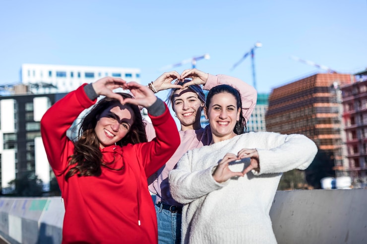 Foto volledige lengte van een gelukkige jonge vrouw die een smartphone gebruikt in de stad.