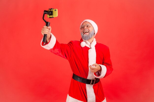 Volledige lengte van een man die tegen een rode achtergrond fotografeert