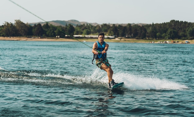 Foto volledige lengte van een man die wakeboard doet in een meer