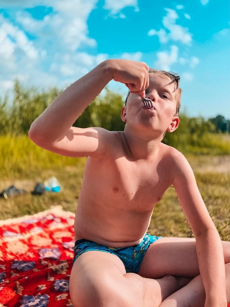 Volledige lengte van hemdloze jongen die op het land zit