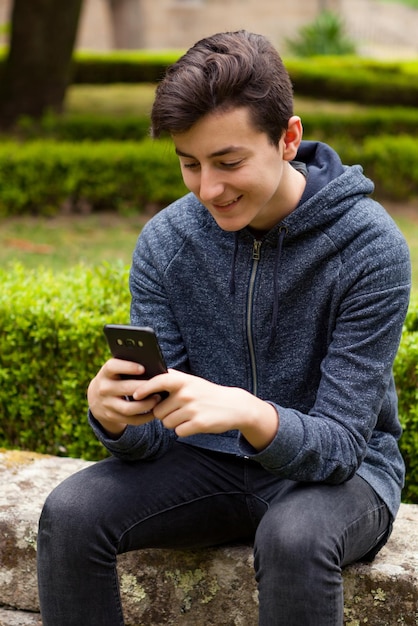 Volledige lengte van jonge man met mobiele telefoon