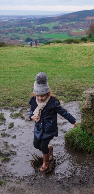 Foto volledige lengte van meisje dat op het land springt