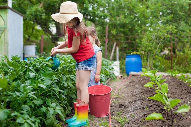 Volledige lengte van meisje met hoed in de tuin