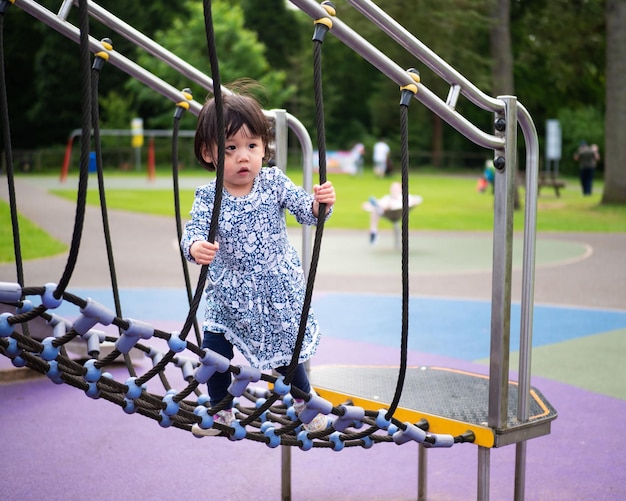 Volledige lengte van meisje op jungle gym op de speeltuin