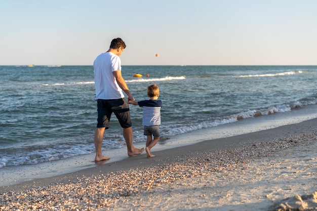 Volledige lengte van moeder met dochter op het strand tegen de lucht