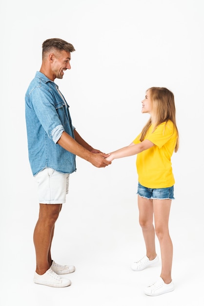 Volledige lengte van mooie blanke familie vader en dochter glimlachend en hand in hand geïsoleerd op wit