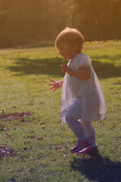 Foto volledige lengte van schattig meisje dat op het veld staat