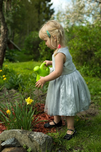 Volledige lengte van schattig meisje water planten in de tuin