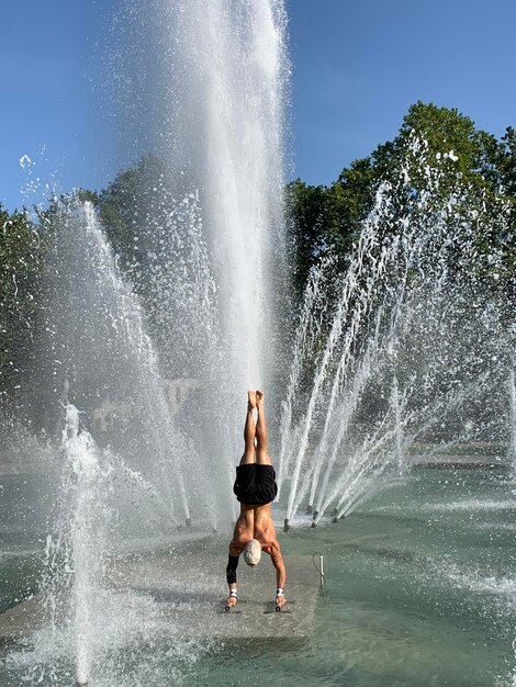 Foto volledige lengte van shirtless man spatten water