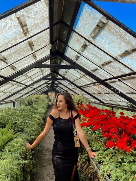 Foto volledige lengte van vrouw die bij bloeiende planten staat