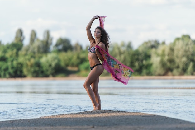 Foto volledige lengte van vrouw met armen opgeheven in de zee