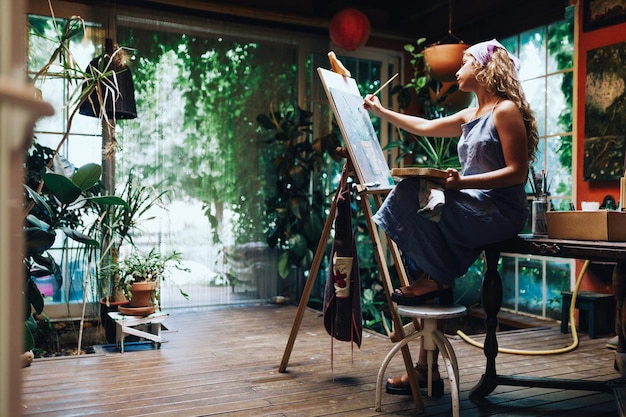 Volledige lengte van vrouw schilderij op easel