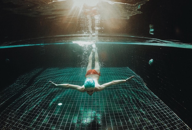 Foto volledige lengte van vrouw zwemmen in het zwembad