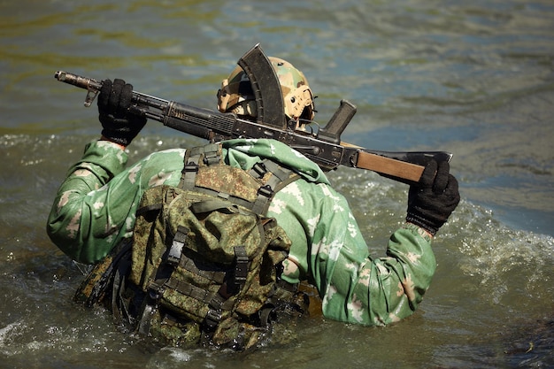 Volledige militaire ervaring Een dagcommando dat door het water rent met automatische geweerreplica