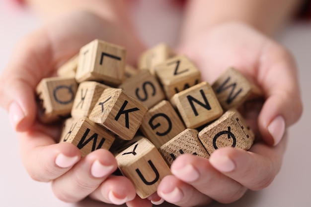Volledige set houten kubussen met letters op de handpalmen close-up alfabetische trainingsset lettertypen