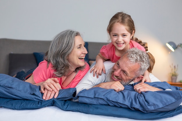 Foto volledige shot gelukkige familie spelen in bed