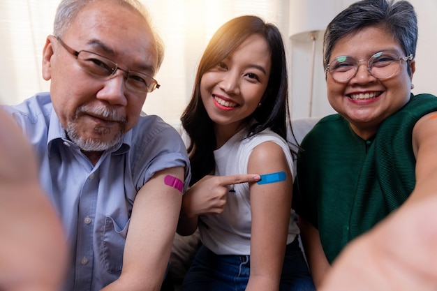 Volledige vaccinaties voor het hele gezin, deze Aziatische mensen nemen een foto en tonen het voltooide vaccin tegen het coronavirus