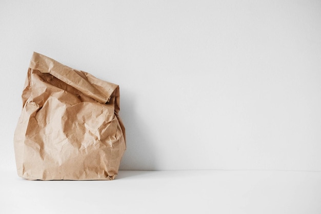 Foto volledige verfrommelde wegwerpzak bruin kraftpapier op een witte achtergrond. kopiëren, lege ruimte voor tekst