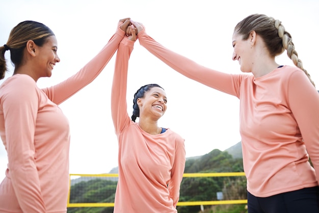 写真 バレーボールのビーチやスポーツの女性ハイタッチでゲームのトレーニングや夏に一緒にトレーニングをするチームフィットネスの女の子のサポートや幸せな友達が砂の上で笑顔で、ブラジルで楽しい試合を始める準備ができています