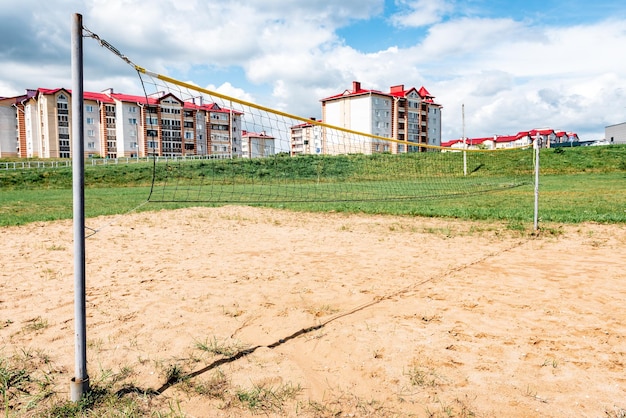 Volleyball court with net on sand near river.