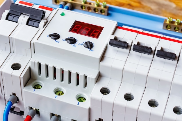 Photo voltage limiter and automatic circuit breakers closeup in the white plastic mounting box