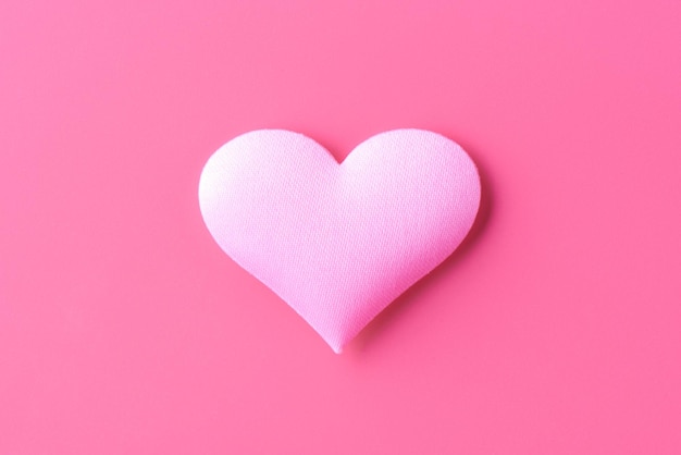 Volume heart on a pink background, a symbol of love and loyalty