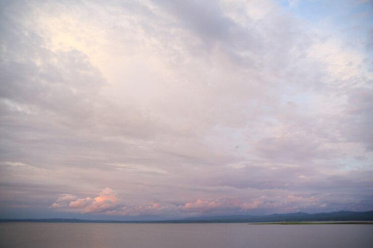 Photo volumetric pink and blue clouds at sunset over the water