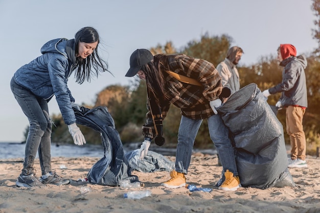 Volunteer concept Young people gathering garbage outdoors