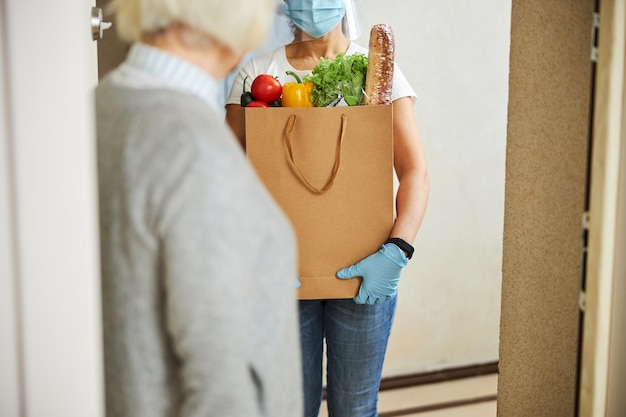 Volunteer delivering food to an aged lady