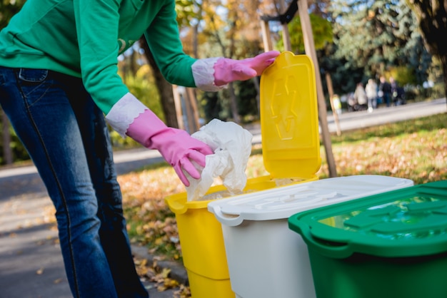 Foto la ragazza volontaria ordina la spazzatura nella via del parco. concetto di riciclaggio.