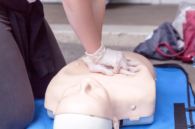 Photo volunteer giving first aid training with mannequin