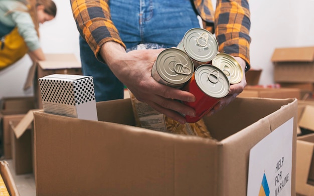 The volunteer packing the bag with groceries and necessary things for people in need