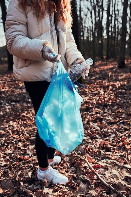 Photo volunteer picking plastic waste to bags concept of plastic pollution and too many plastic waste