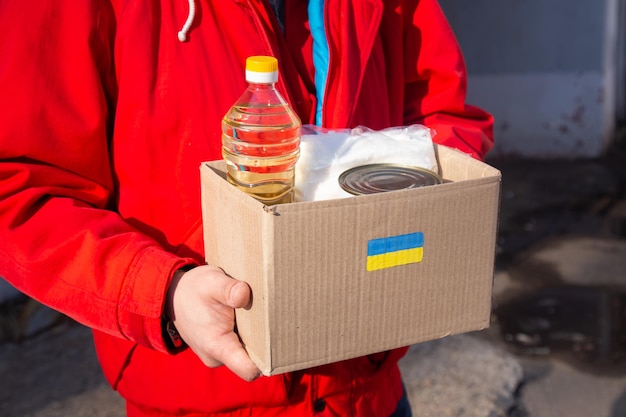 Волонтер готовит коробку с едой для украинских военных беженцев, гуманитарная помощь и концепция помощи