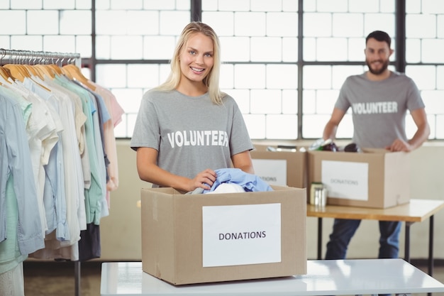 Volunteer separating clothes from donation box 