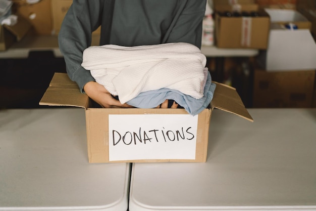 Photo volunteer teengirl preparing donation boxes for people