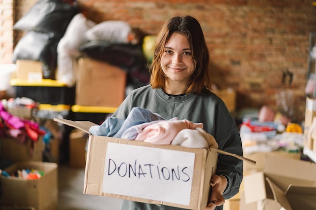 Volunteer teengirl preparing donation boxes for people