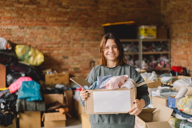 Volunteer teengirl preparing donation boxes for people