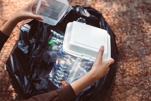 Una donna volontaria tiene i rifiuti di plastica espansa nel parco pubblico. buona mente cosciente. smaltire il concetto di riciclaggio e gestione dei rifiuti