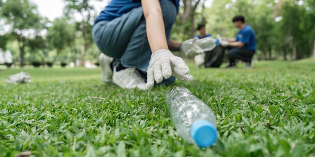 Photo volunteer young woman collecting garbage picking land pollution environmental problem