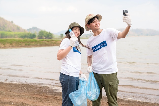 Volunteers from the Asian youth community using rubbish bags cleaning up nature par