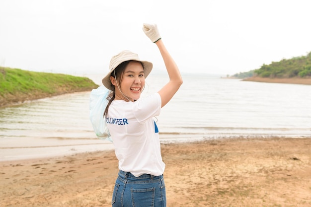 Volunteers from the Asian youth community using rubbish bags cleaning up nature par