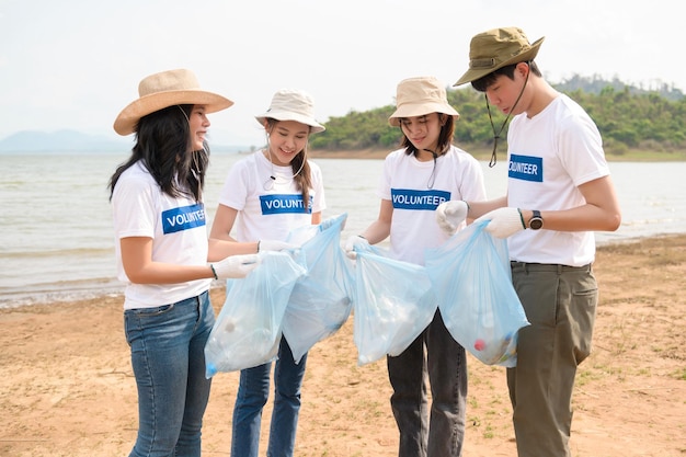 Volunteers from the Asian youth community using rubbish bags cleaning up nature par