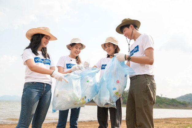 Volunteers from the Asian youth community using rubbish bags cleaning up nature par