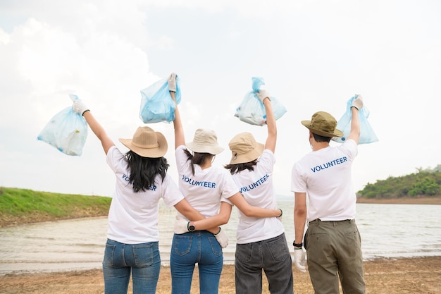 Volunteers from the Asian youth community using rubbish bags cleaning up nature par