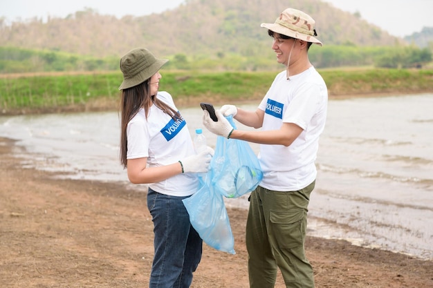 Volunteers from the Asian youth community using rubbish bags cleaning up nature par